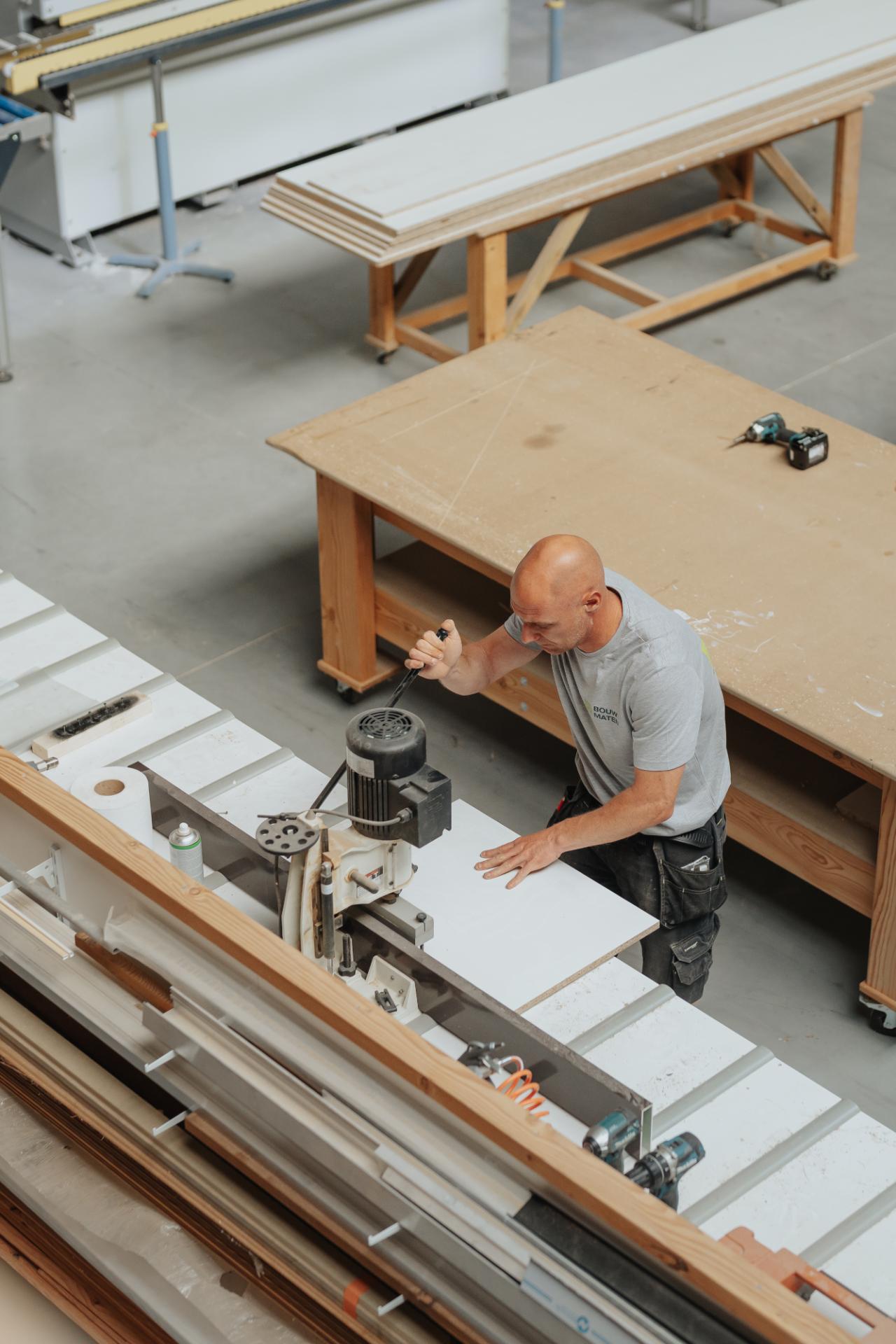 Houtbewerker zaagt houten onderdelen in de werkplaats
