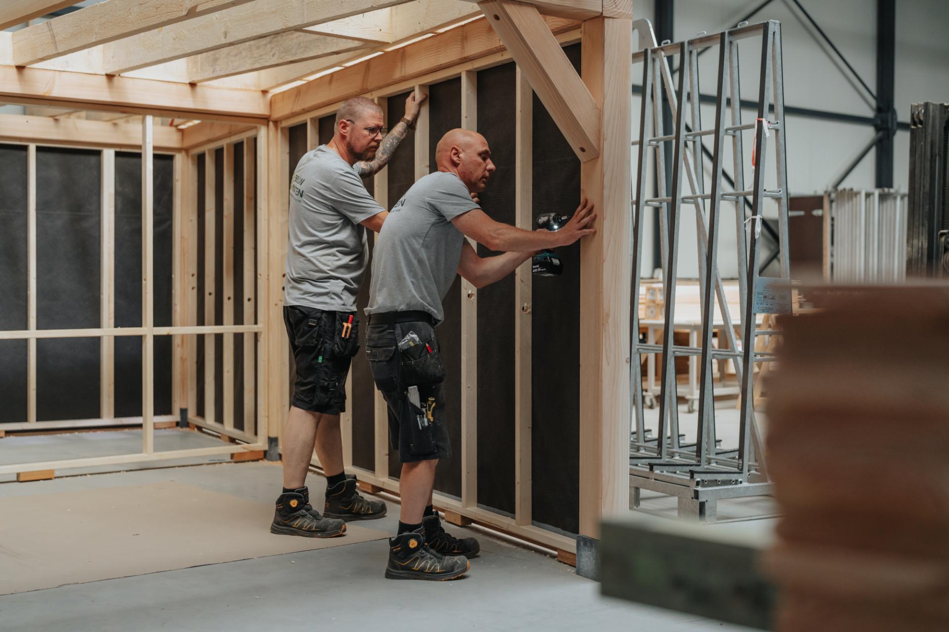 Vakmensen plaatsen een houten constructie op maat