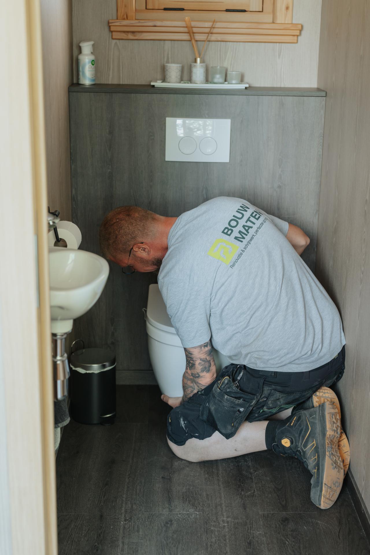 Vakman plaatst toilet tijdens badkamer renovatie