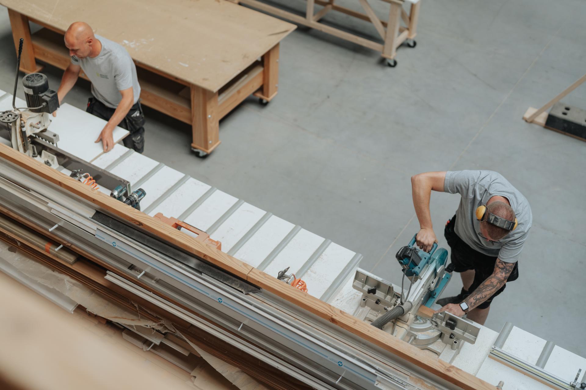 Schrijnwerker meet en zaagt hout voor maatwerk projecten